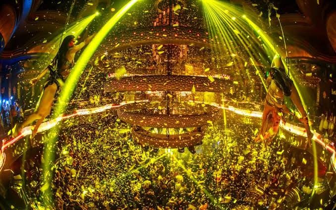 OMNIA Nightclub Las Vegas Club Floor 2 OMNIA Nightclub Las Vegas. Party Bus Tours. Yellow lights with people dancing.